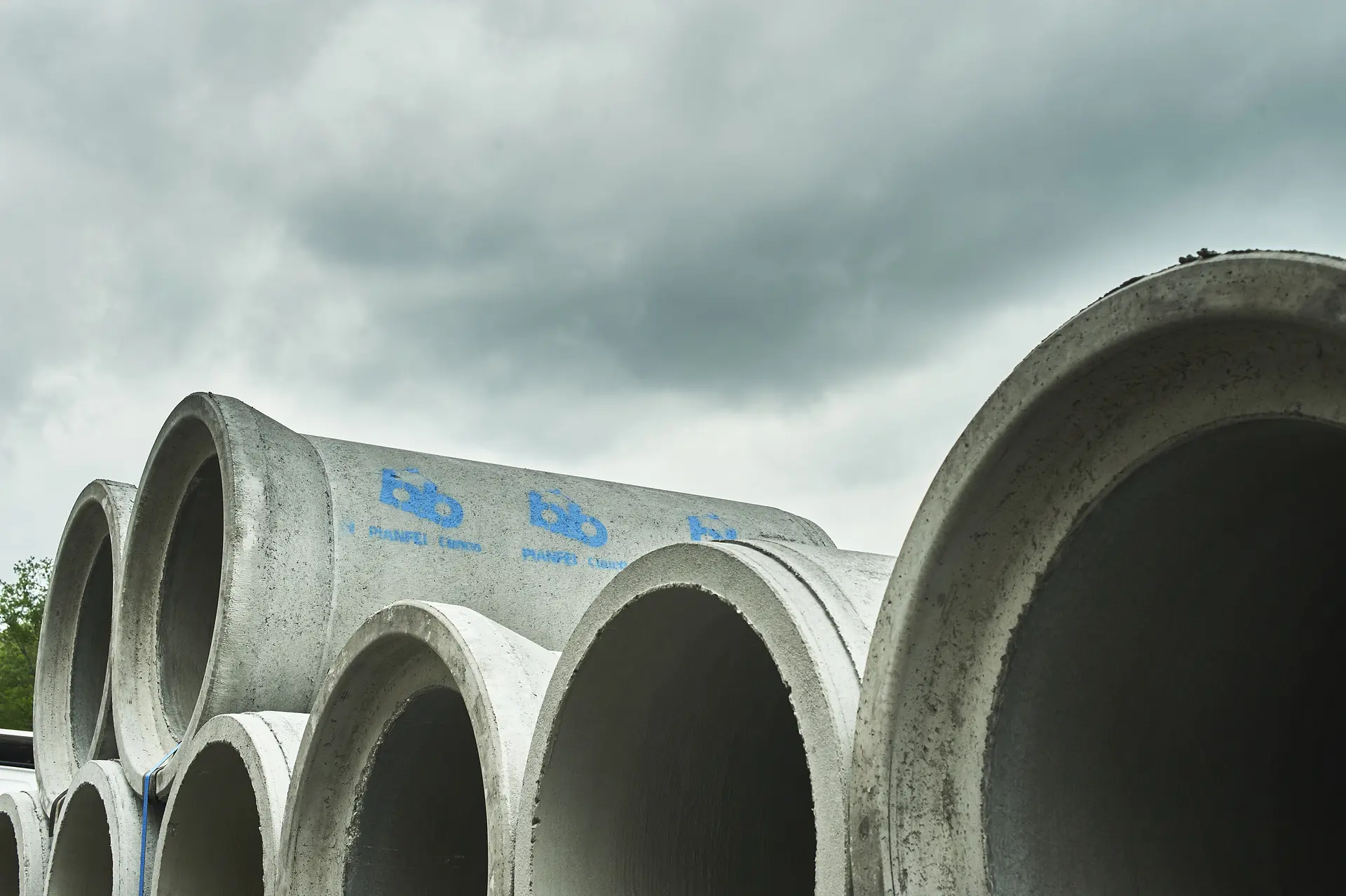 Tuyaux de béton empilés sur un site industriel.